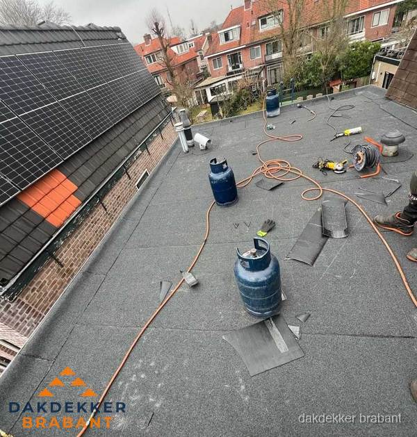 Daklekkage repareren met brandgereedschap op plat dak in Brabant