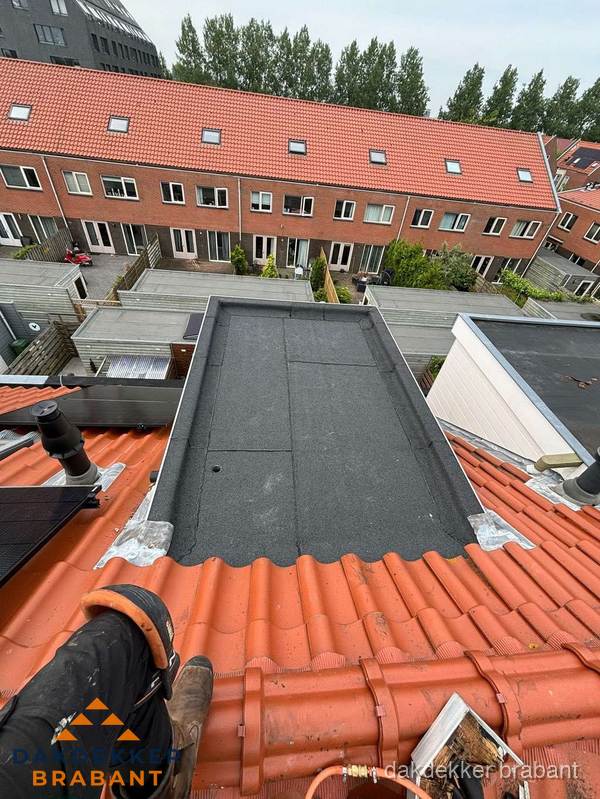 Bitumen dak reparatie op plat dak tussen dakpannen in Brabant