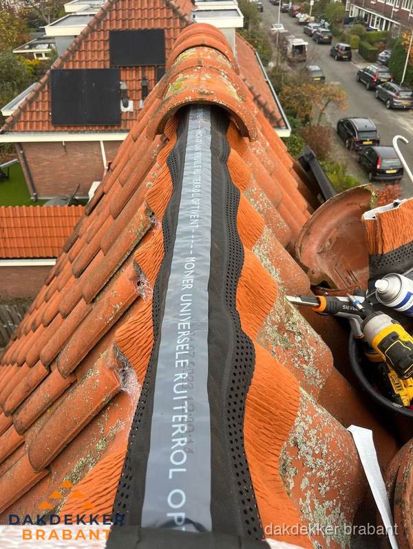 Dakdekker vervangt nokvorst met ruiterrol op pannendak in Brabant Dakdekker vervangt nokvorst met ruiterrol op pannendak in Brabant