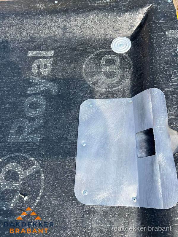 Dakdoorvoer met metalen afvoerplaat op bitumen dak in Brabant