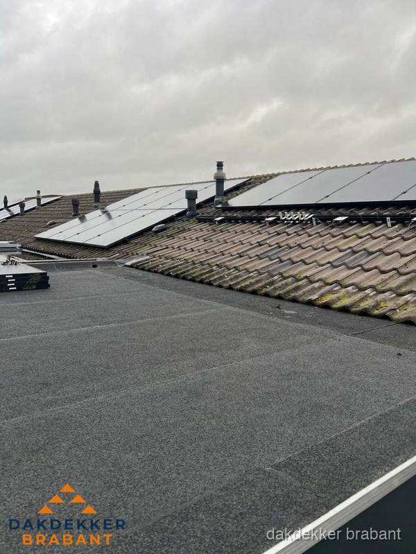 Bitumen dakbedekking op plat dak met aansluitend pannendak en zonnepanelen in Brabant