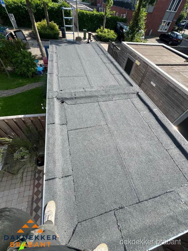 Bitumen plat dak rijtjeswoning vanuit dakdekker perspectief in Brabant